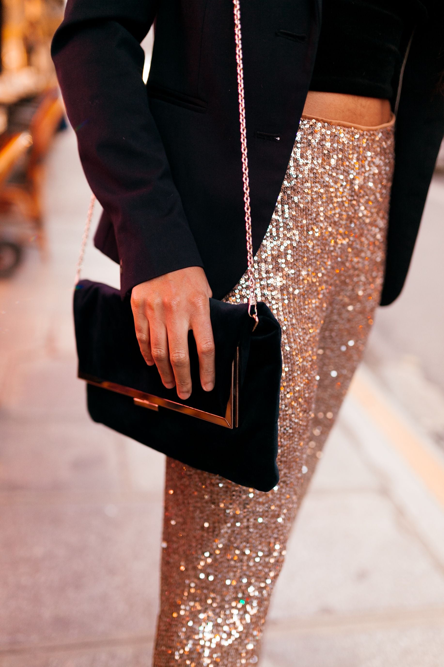 Elegant woman in glamorous outfit carrying a velvet handbag on a city street at night — editorial lifestyle photography, licensed via Pexels License